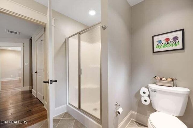 bathroom with walk in shower, tile patterned flooring, and toilet