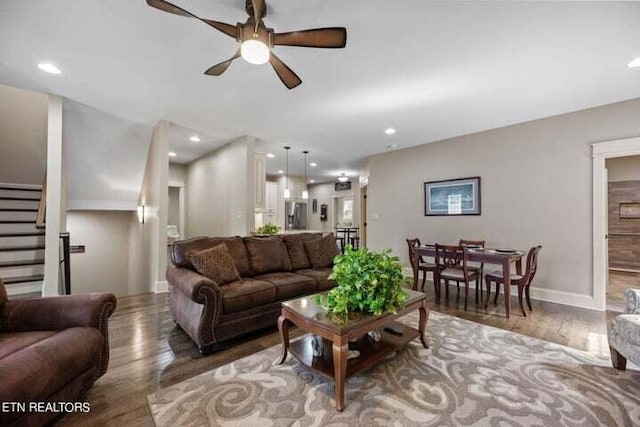 living room with wood-type flooring and ceiling fan