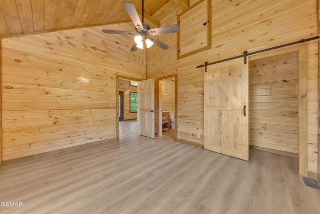 2641 Willow Heights Way, Sevierville, TN 37876 - unfurnished bedroom featuring wooden walls, a barn door, wooden ceiling, and light wood-style flooring