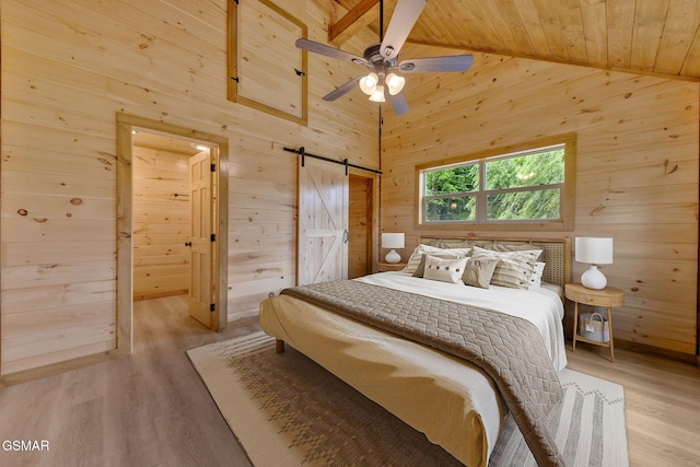 2641 Willow Heights Way, Sevierville, TN 37876 - bedroom with wooden walls, wood ceiling, a barn door, light wood-type flooring, and high vaulted ceiling
