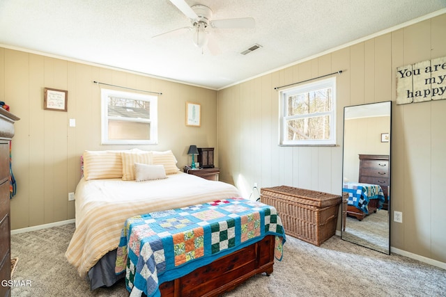 bedroom with multiple windows, ceiling fan, light carpet, and a textured ceiling