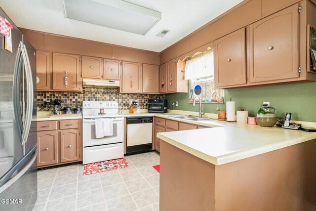 kitchen with sink, backsplash, white appliances, and kitchen peninsula