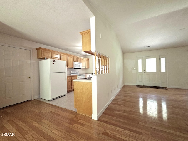 2865/2869 Happy Hollow Rd, Sevierville, TN 37862 - kitchen featuring white appliances, light wood-type flooring, a peninsula, vaulted ceiling, and light countertops
