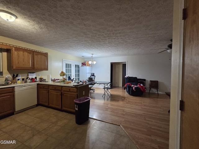 2865/2869 Happy Hollow Rd, Sevierville, TN 37862 - kitchen with white dishwasher, a peninsula, a textured ceiling, light countertops, and brown cabinetry