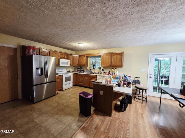 2865/2869 Happy Hollow Rd, Sevierville, TN 37862 - kitchen with white appliances, a peninsula, light countertops, plenty of natural light, and a textured ceiling