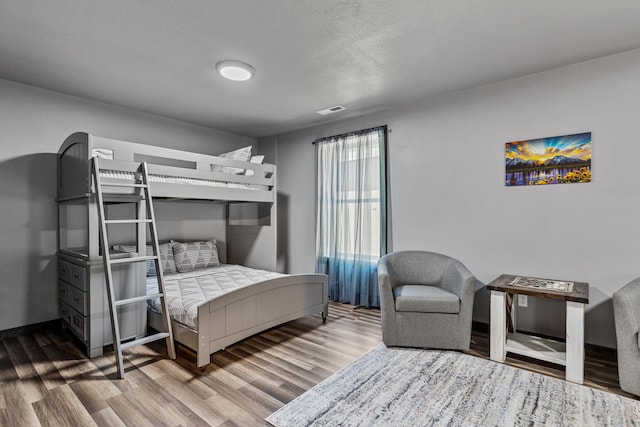 bedroom featuring hardwood / wood-style floors and a textured ceiling