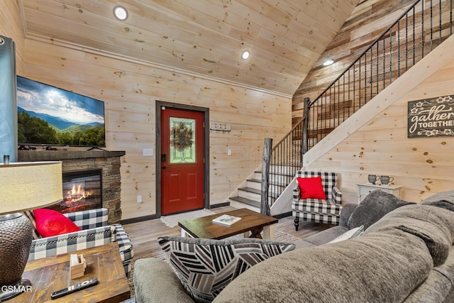 living room with wood walls, high vaulted ceiling, light hardwood / wood-style flooring, wooden ceiling, and a fireplace