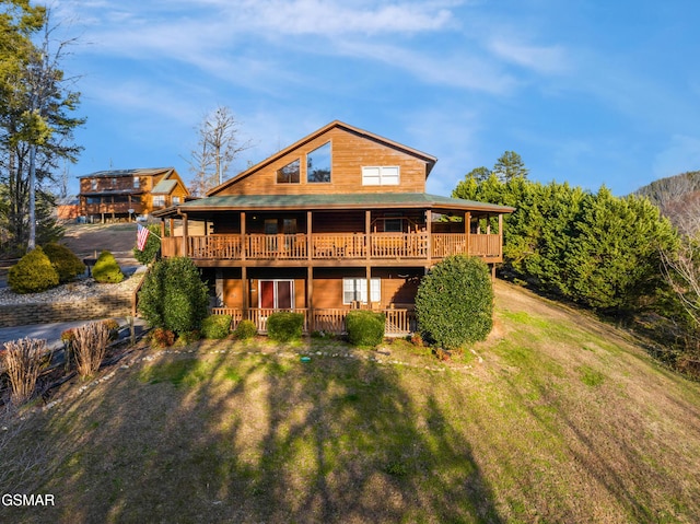 back of house featuring a deck and a lawn