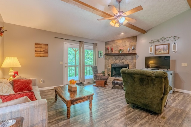 3078 Winding Way, Cosby, TN 37722 - living area with lofted ceiling, wood finished floors, ceiling fan, a stone fireplace, and a textured ceiling