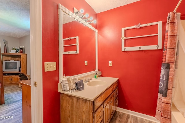 3078 Winding Way, Cosby, TN 37722 - bathroom featuring wood finished floors, vanity, a textured ceiling, and shower / tub combo with curtain