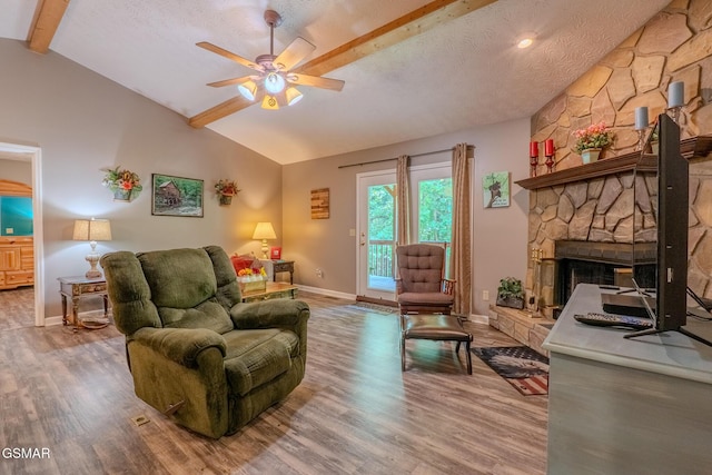 3078 Winding Way, Cosby, TN 37722 - living area with light wood-type flooring, a ceiling fan, a stone fireplace, and a textured ceiling