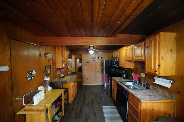 kitchen featuring wooden walls, sink, dark wood-type flooring, beam ceiling, and black appliances