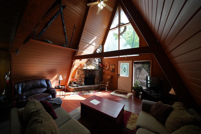 living room featuring ceiling fan, wooden ceiling, wood walls, wood-type flooring, and a fireplace