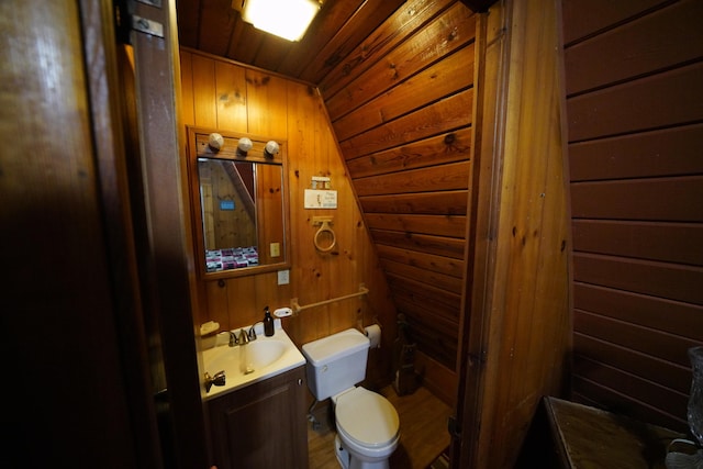 bathroom featuring lofted ceiling, toilet, wooden walls, vanity, and wood ceiling