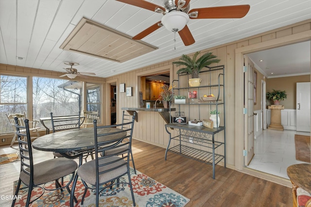 dining space with ornamental molding, wood ceiling, and wood finished floors