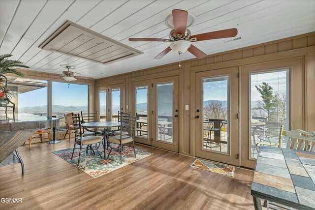 sunroom / solarium featuring wood ceiling, visible vents, a mountain view, and a wealth of natural light