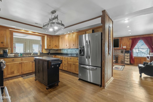 kitchen with stainless steel fridge, tasteful backsplash, visible vents, dark countertops, and light wood-style flooring