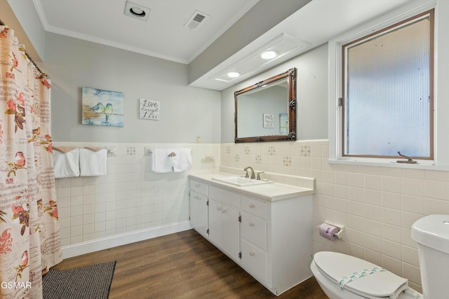 full bathroom featuring toilet, ornamental molding, wood finished floors, and visible vents