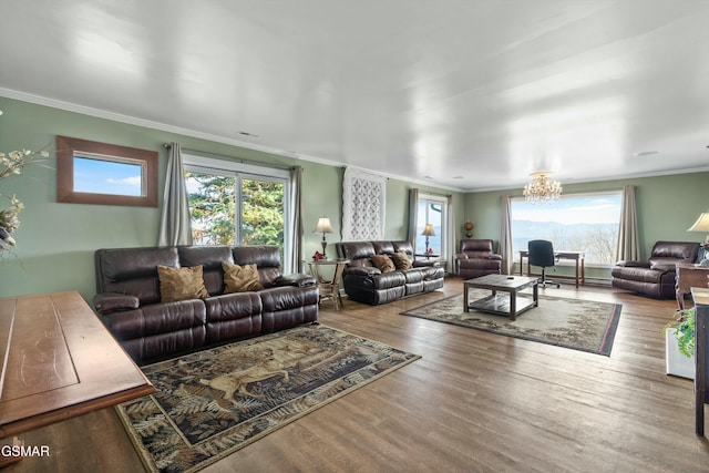 living area featuring ornamental molding, wood finished floors, and a notable chandelier