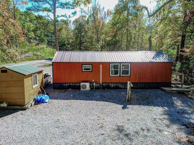 view of home's exterior with ac unit and a storage unit