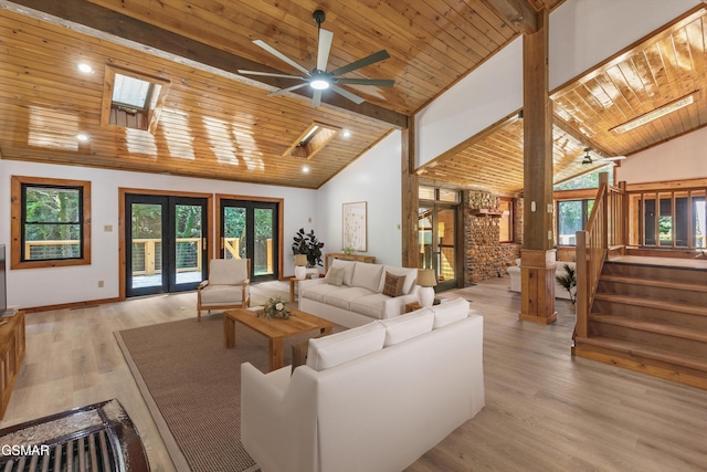 living area featuring stairs, french doors, a skylight, and wooden ceiling