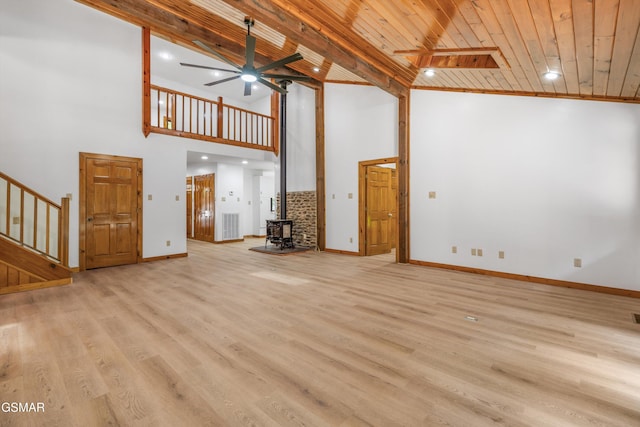 unfurnished living room featuring a ceiling fan, wood ceiling, light wood-style flooring, stairway, and a wood stove