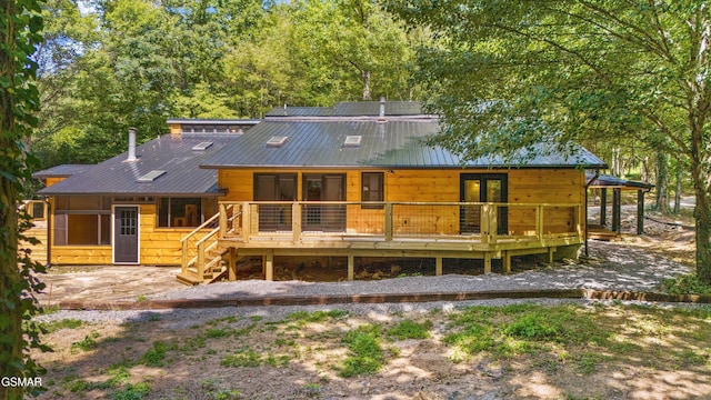 back of house with metal roof and a wooden deck