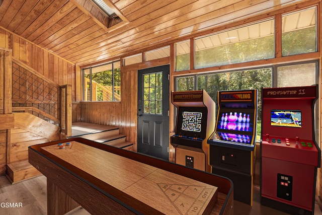 recreation room featuring a skylight, wood ceiling, wood walls, and wood finished floors