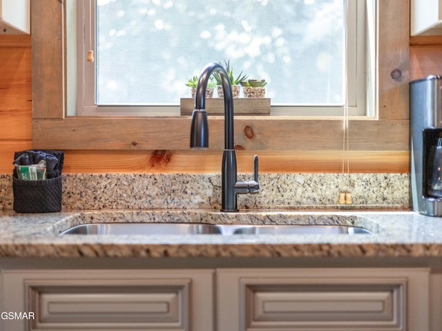 details featuring light stone countertops and sink