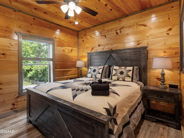 bedroom featuring wood walls, ceiling fan, wood-type flooring, and wooden ceiling