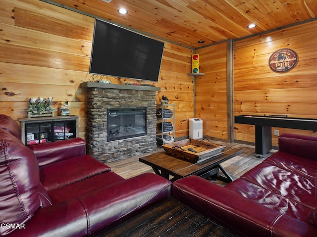 living room with hardwood / wood-style floors, wooden walls, a fireplace, and wooden ceiling