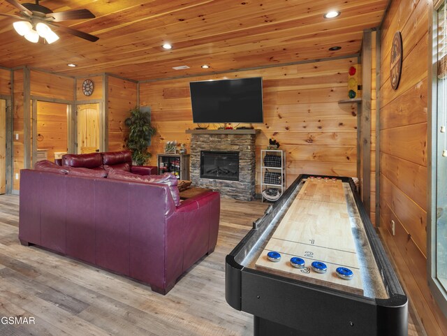 living room featuring wood walls, a fireplace, wood ceiling, and light hardwood / wood-style floors