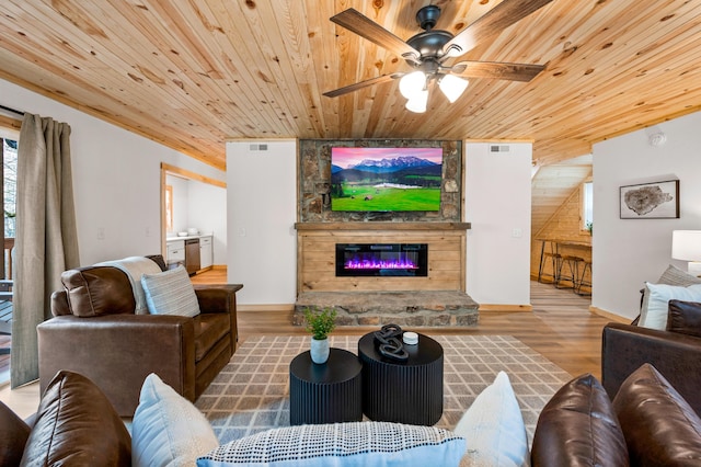 living room with a stone fireplace, wood finished floors, wood ceiling, and a ceiling fan