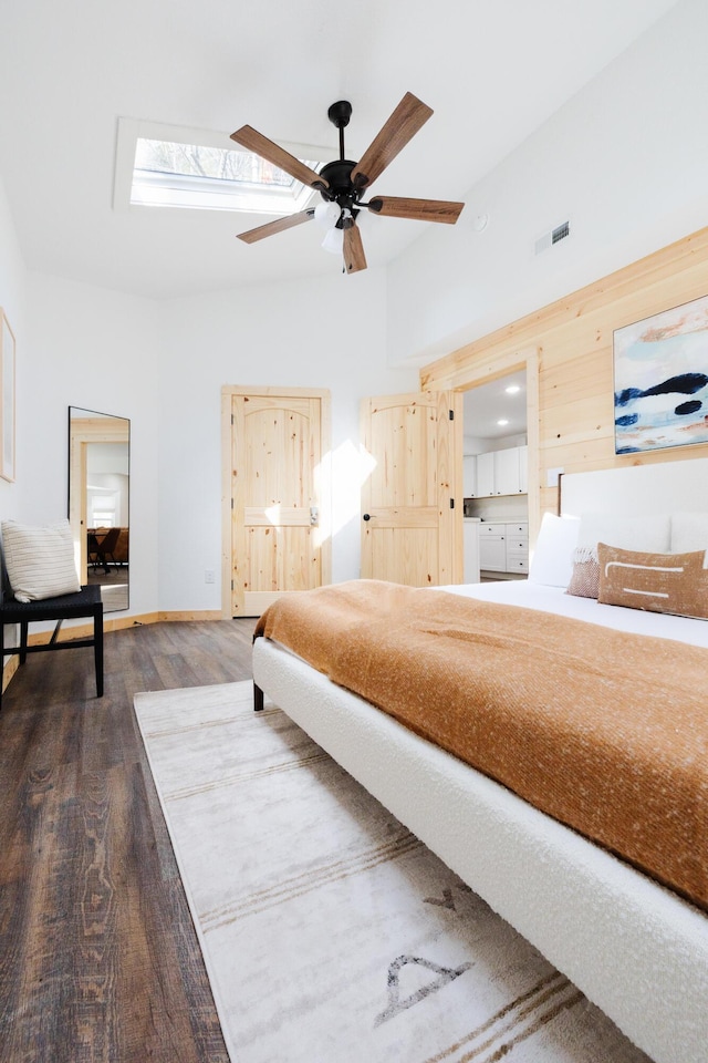 bedroom featuring high vaulted ceiling, wood finished floors, and visible vents