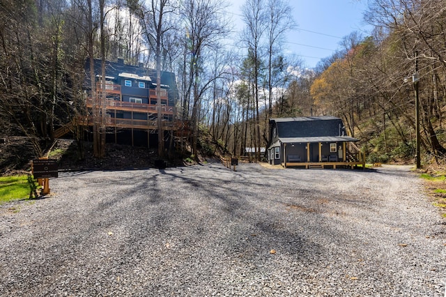 view of front of home with a wooded view and a wooden deck