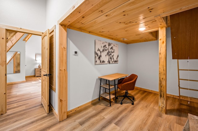 office space with light wood finished floors, wooden ceiling, and baseboards