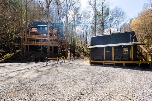 rear view of house featuring roof with shingles