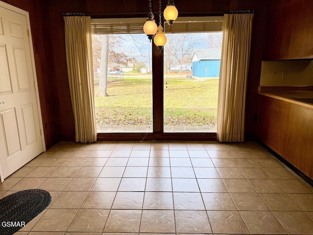 unfurnished dining area with wood walls and light tile patterned flooring