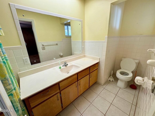 bathroom with tile patterned flooring, vanity, toilet, and tile walls