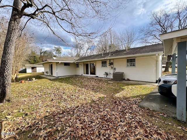 rear view of property featuring central AC and a yard