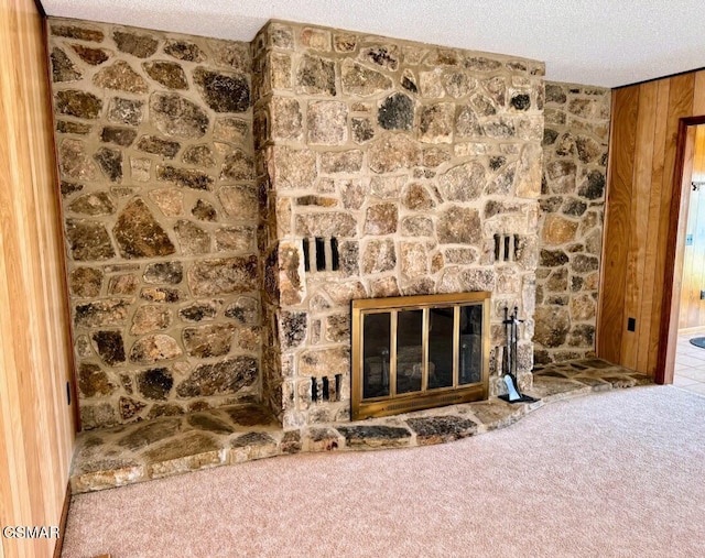 room details with a fireplace, a textured ceiling, carpet floors, and wooden walls