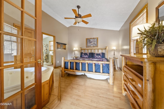 bedroom featuring vaulted ceiling, a textured ceiling, light wood-style flooring, and baseboards