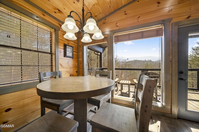 dining area featuring a healthy amount of sunlight, wooden ceiling, a chandelier, and wood finished floors