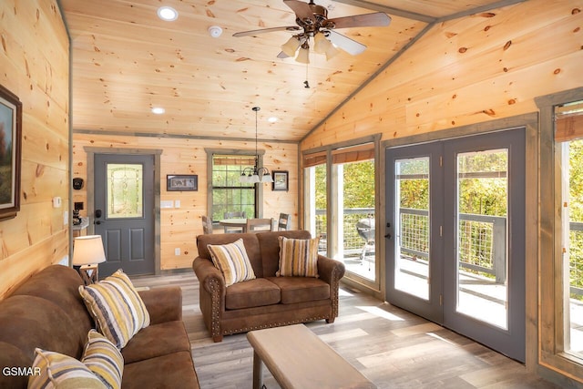 living area with wooden walls, a ceiling fan, wooden ceiling, light wood-style flooring, and french doors