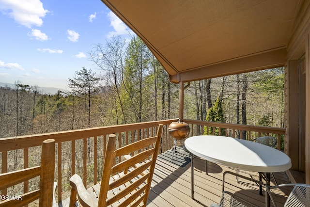 wooden terrace featuring a forest view