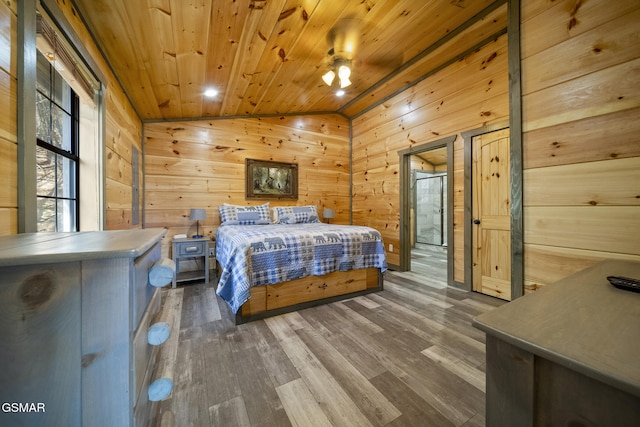 bedroom with lofted ceiling, wooden ceiling, wood walls, and wood finished floors