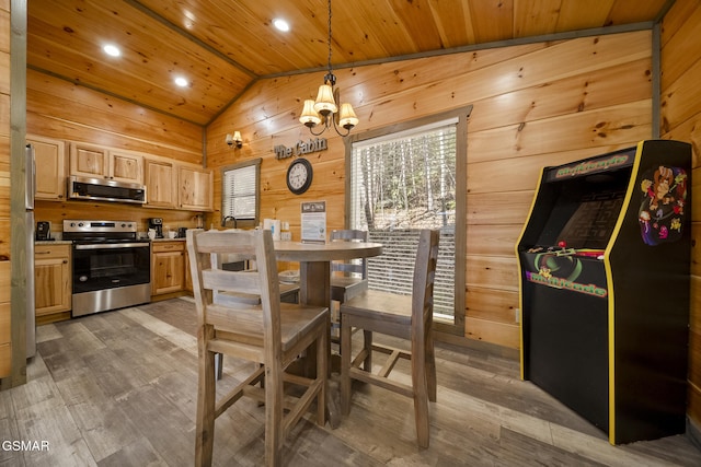 kitchen with wood walls, wood ceiling, appliances with stainless steel finishes, and light brown cabinetry