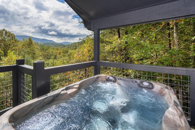 exterior space with a mountain view, a forest view, and a jacuzzi