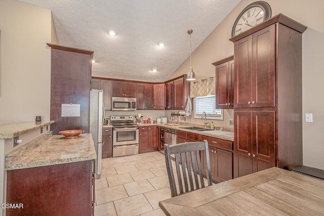 kitchen featuring appliances with stainless steel finishes, a textured ceiling, decorative light fixtures, vaulted ceiling, and sink