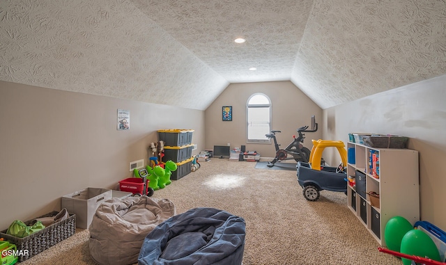 rec room featuring a textured ceiling, lofted ceiling, and carpet flooring